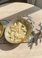 Bowl of potato chips on a decorative mat with a wooden surface