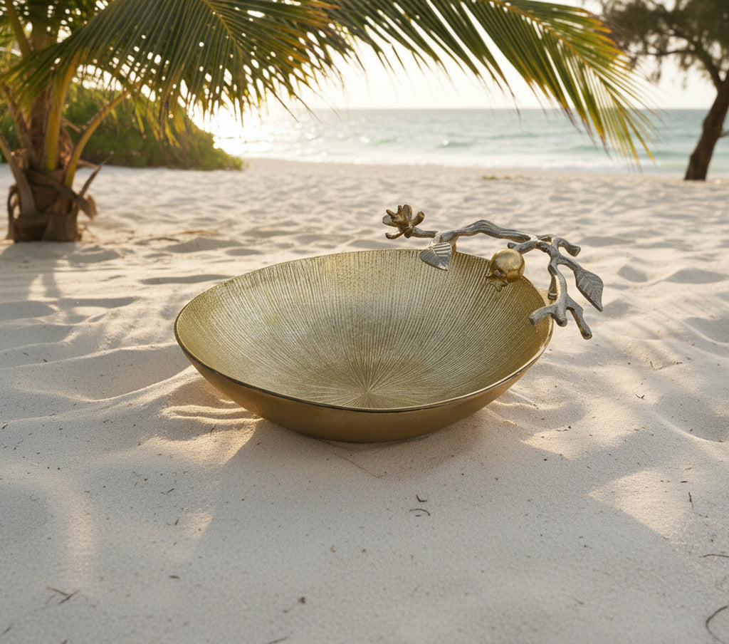 Gold decorative bowl with silver leaf and berry design on a white background